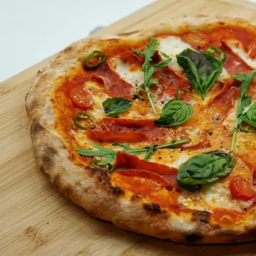 Foto de ejemplo: pizza con morrones y hojas verdes
